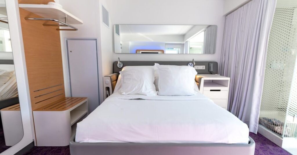 Quarto de hotel com cama de casal, mesa e espelho